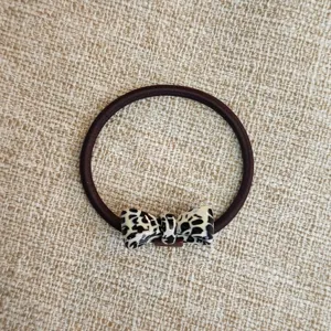 Primo piano dettagliato di un elegante elastico per capelli con fiocco in acetato.