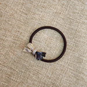 Vista dettagliata del grazioso elastico per capelli con fiocco in acetato e banda elastica.