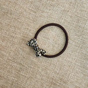 Dettaglio di un grazioso elastico per capelli con fiocco in acetato per lo styling quotidiano.