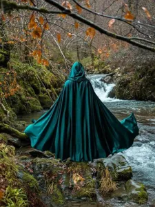 Detailed view of the dark green hooded velvet cloak in a forest stream setting, ideal costume.