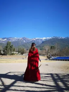 Velvet hooded cloak detail shot, long red cape for stage performance and outdoor scenic wear.