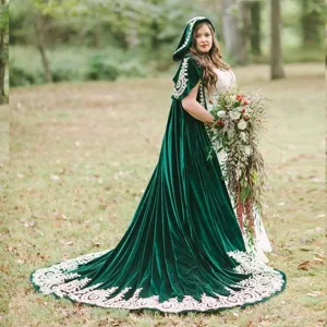 Detailed view of the dark green velvet hooded cloak featuring elegant white lace embroidery.