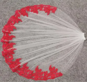 Detailed shot of ivory bridal veil with red floral embroidery lace and wedding comb accessory.
