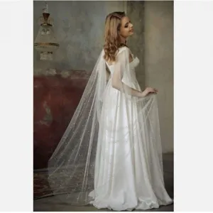Elegant bridal long shimmering mesh cape with pearls, perfect wedding dress accessory.