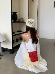 Vue détaillée d'un sac bandoulière rouge tendance en cuir pour téléphone portable.