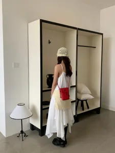 Gros-plan du sac bandoulière mini en cuir rouge élégant dans une pièce minimaliste.