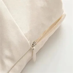 Close-up detail of cream canvas fabric with hidden zipper, clean and minimalist design.
