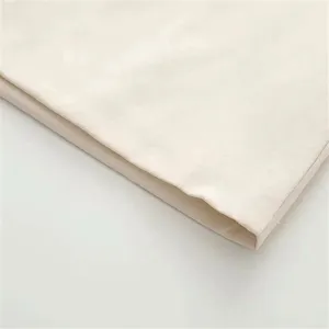 Detailed fabric closeup of sleeveless dress, soft texture, elegant beige material.