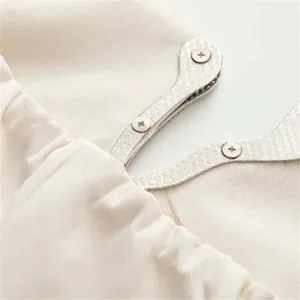 Detail view of structured waist cinching metal boning dress construction in solid beige.