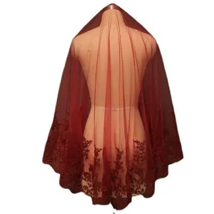 Vista dettagliata del velo da sposa rosso scuro con delicati ricami in pizzo e tessuto.