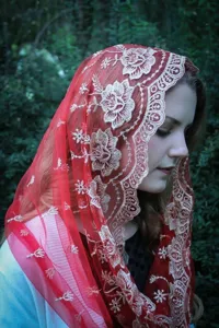 Close-up detail shot of the elegant red mesh embroidered headscarf featuring floral patterns.