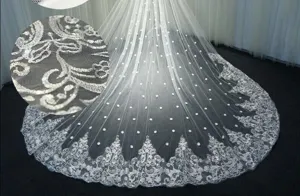 Lange bruidssluier detail, elegante kanten borduursel met sprankelende pailletten accenten.