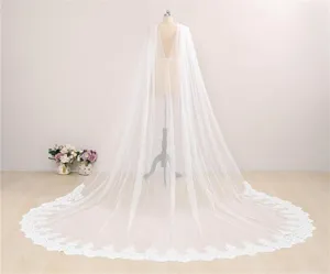 Gedetailleerd overzicht van de lange witte bruidskantcape met fijne bloemenkantrand.