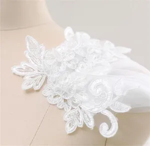Schitterend detail van witte kanten bloemborduursel op de prachtige bruidssluier.