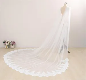 Gedetailleerd overzicht van een lange witte bruidscape met elegante kanten afwerking.