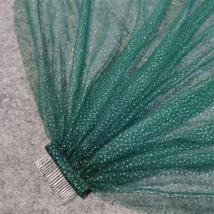 Close-up van de details van de donkergroene glitter tule bruidssluis met metalen kam.