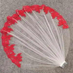 Detail close-up view of elegant ivory bridal veil featuring striking red floral lace trim and comb.
