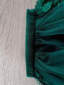 Close up detail of dark green sequin lace mesh tulle fabric trim for wedding bridal veil accessory