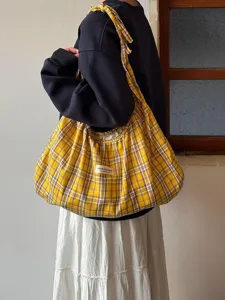 Detail shot of the yellow plaid pleated canvas tote bag, showing slouchy casual design.