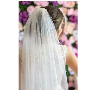 Pearl embellished bridal veil detail shot, elegant wedding tulle accessory for brides.