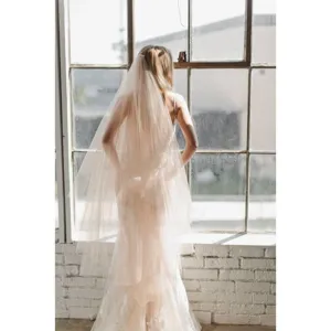 Close-up detail of the elegant bridal veil showing delicate tulle fabric texture in a bright room.