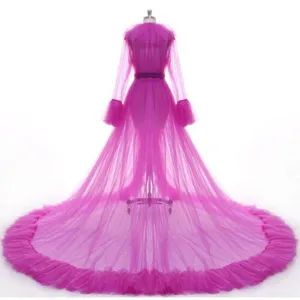 Sheer magenta tulle cape detail, long sleeves, dramatic floor train, bridal gown overlay.