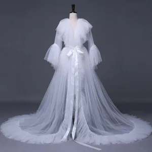 White sheer tulle bridal robe with ruffles, long sleeves, and a long train for wedding.