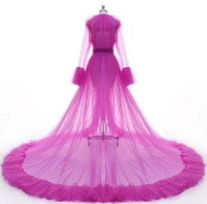 Elegant pink mesh bridal cape with long sleeves and dramatic floor length train for wedding dress.