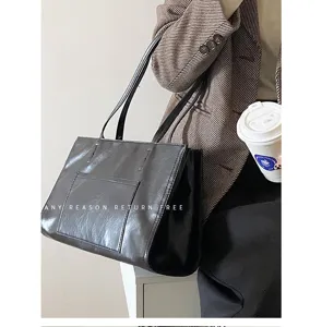 Detail shot of the large capacity black leather shoulder tote bag, showing daily commuting style.