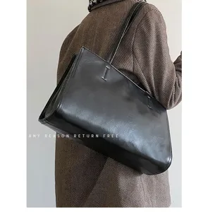 Detail view of a minimalist black PU leather tote bag, perfect for daily commuting use.