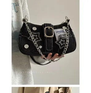 Vista detallada del bolso de hombro de denim vintage con bordado de estrella y cadena.