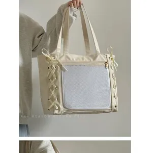 Detailansicht der eleganten beigen Schultertasche mit Seitenschleifen und vorderer Netztasche.