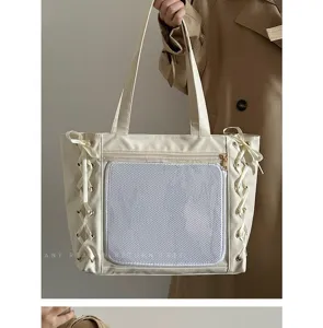 Detailansicht der süßen cremefarbenen Tasche mit Schleifenbänder und transparenter Netztasche.