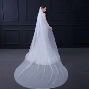 Gedetailleerd overzicht van de elegante witte bruids tule cape sluier met vloeiende stof.
