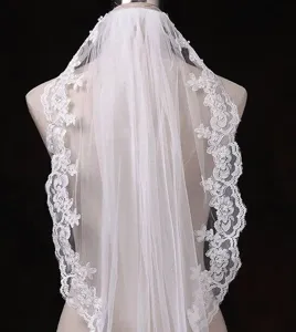 Elegante velo da sposa avorio con delicato ricamo in pizzo floreale e design in rete trasparente.