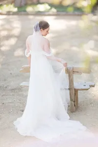 Long wedding veil detail shot showing soft tulle fabric and elegant cut edge design style.