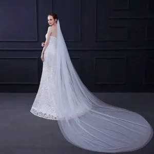 Gedetailleerd overzicht van de elegante lange witte bruidssluier en trouwjurk voor foto's.