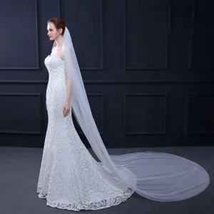 Gedetailleerd overzicht van elegante witte kanten zeemeermin trouwjurk met lange sluier.