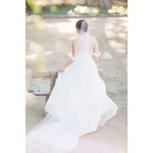 Long bridal veil with comb and cut edge in white, elegant wedding accessory for women.
