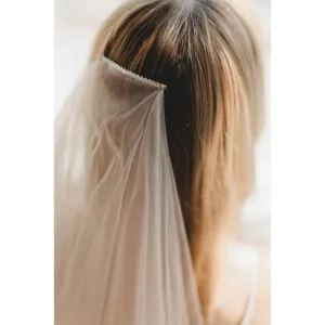 Detailed view of a double-layer waltz bridal veil with a built-in comb for elegant wedding styling.