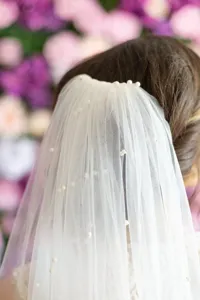 Bridal pearl veil detail view, white tulle wedding hair accessory with scattered pearls.