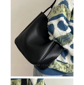 Λεπτομερής όψη casual μινιμαλιστικής μαύρης δερμάτινης τσάντας ώμου για καθημερινή χρήση.