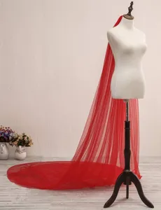 Detail view of the long red bridal veil featuring soft double-layer mesh and elegant trailing style.