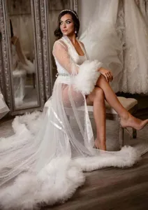 Elegantes weißes Tüll-Morgenkleid mit Perlenakzenten und feinen gefiederten Manschetten.