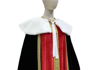 Detailed view of red and black velvet costume cape with white fur collar and woven trim.