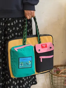 Detailed shot of color-blocked laptop bag featuring multiple pockets and durable straps.
