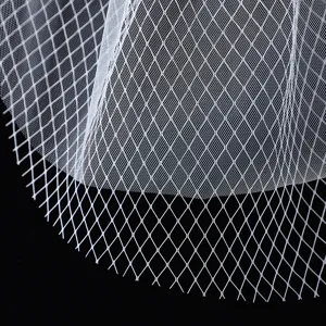 White bridal mesh veil detail, diamond pattern net fabric, elegant short wedding headwear accessory.