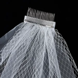 Bridal veil detail shot, white mesh fabric with metal hair comb, vintage wedding hair accessory