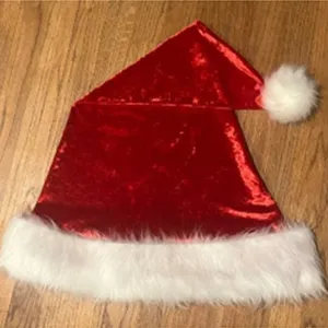 Primo piano dettagliato di un cappello da Babbo Natale rosso in velluto con bordo in peluche.