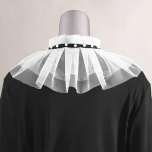 Vista dettagliata del finto colletto in tulle bianco con decorazione di perle e nastro nero.